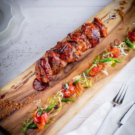 Šašlik z krůty marinovaný v kefíru, fazolové lusky se slaninou, koktejlová rajčata a artyčoky